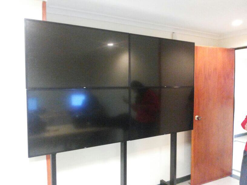 Montaje de 4 televisores en estructura videowall con 4 platinas para sobreposicion de televisores
