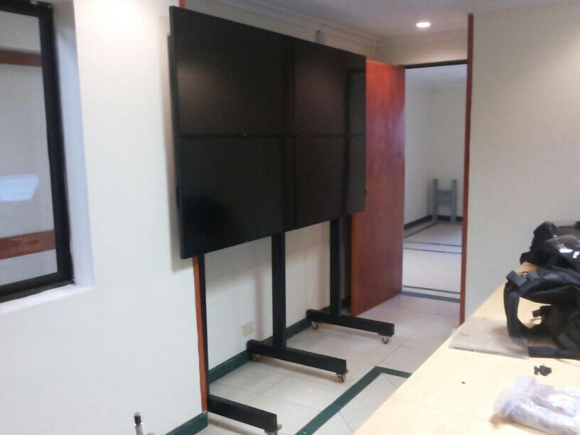 Soporte de piso movil para 4 televisores anclados a la pared